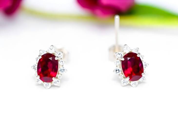 Charming Oval Ruby Earrings Adorned with Diamonds on White Isolate